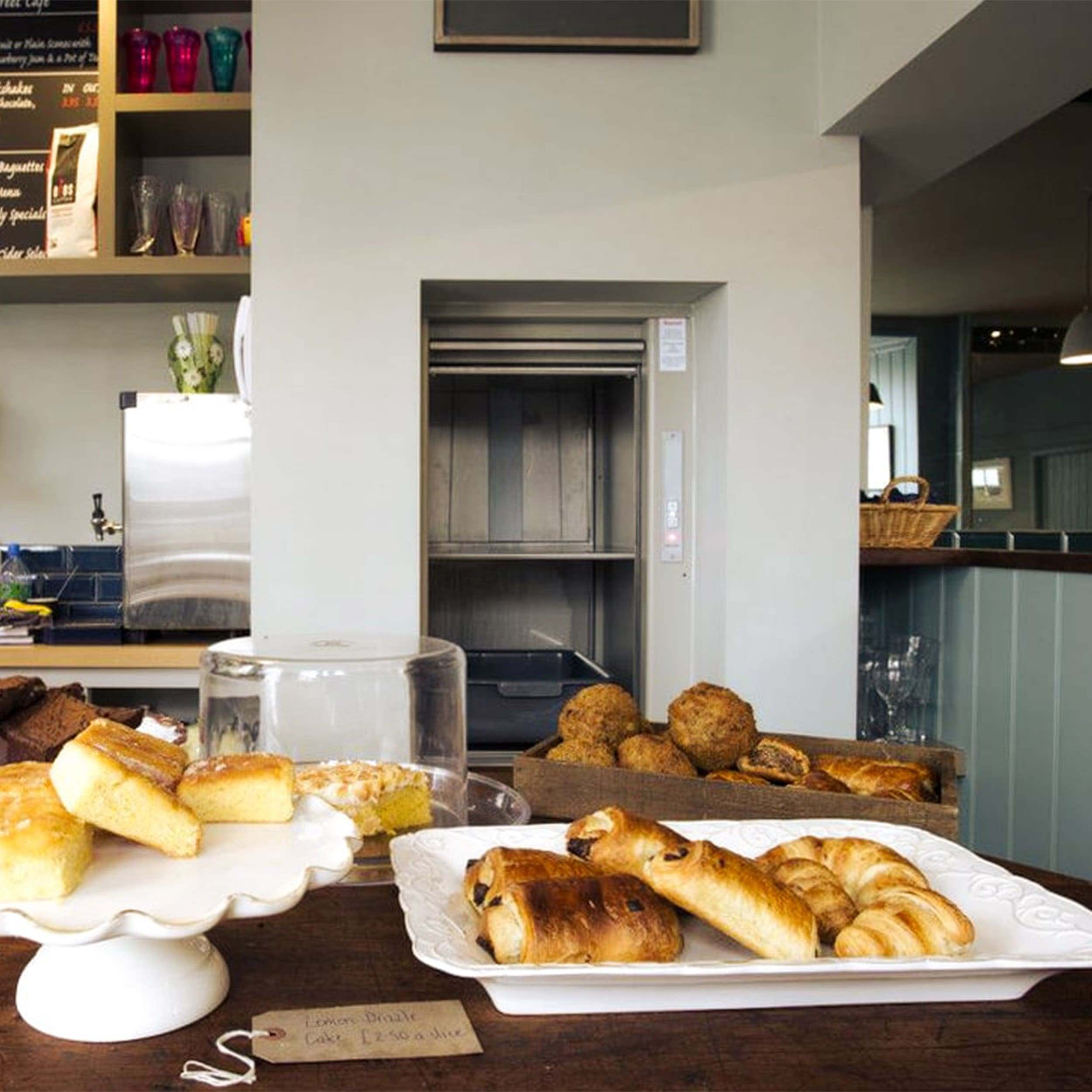 Open stainless dumbwaiter loaded with dishes