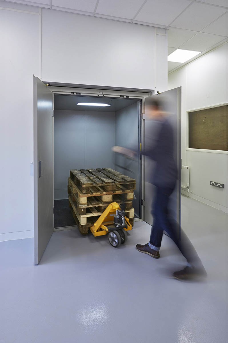 Stainless freight lift with a loaded cart